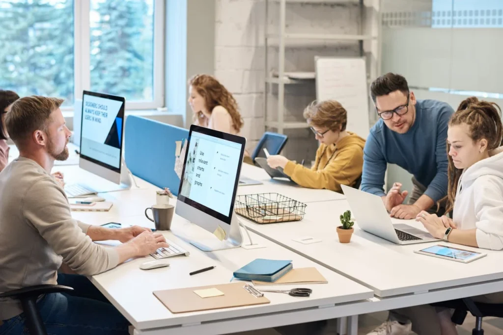 A diverse group of professionals collaborating at a desk in a modern office environment.